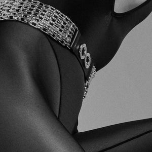 La ceinture bijou ARIA de la maison IINFYNII s’impose comme une pièce de tension et de contraste. Le jeu entre matière mate et chaînes métalliques crée une ligne graphique nette, pensée pour souligner la taille avec autorité. À mi-chemin entre accessoire et bijou, elle structure la silhouette et apporte une dimension presque cérémonielle à l’allure. Portée seule ou en superposition, ARIA affirme un langage visuel radical, précis, sans compromis.