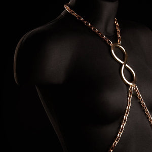 Chaîne de corps ARIA IINFYNII en métal doré portée sur un bustier noir, accessoire graphique et structurant proposé par Brigade Mondaine Paris