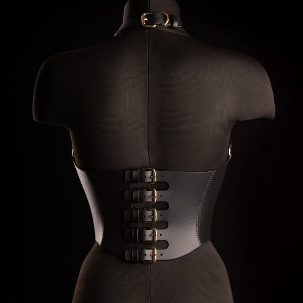 Corset Bondage HOSTIA IINFYNII noir avec sangles et anneaux métalliques porté sur un top en mesh, pièce structurée proposée par Brigade Mondaine Paris
