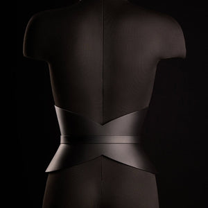 Corset ceinture HUDIA IINFYNII en cuir noir avec fermoir métallique infini porté sur un tailleur noir, accessoire structurant et graphique proposé par Brigade Mondaine Paris