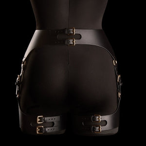 Porte-jarretelles Neria en cuir noir IINFYNII présenté chez Brigade Mondaine Paris, porté sur mannequin, taille haute structurée, sangles réglables et finitions métalliques dorées.