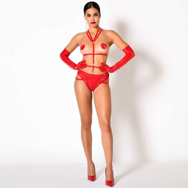 Harnais Nicole CATANZARO rouge porté sur body noir en tulle, avec sangles ajustables et anneaux métalliques, accessoire haut de gamme proposé par Brigade Mondaine.