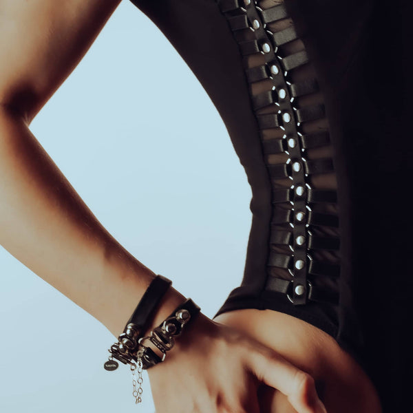 Le body Accented de Lalita en bambou doux épouse les courbes avec ses ornements métalliques faits à la main, et le bracelet HerCuff en cuir italien et argent sterling avec cœurs suspendus crée un contraste sensuel et audacieux.