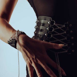 Ceinture corset en cuir et chaînes inox, doublée de daim pour confort. Manchette en cuir italien avec chaîne en argent sterling. Ajustables, raffinées et sensuelles. Modèles sur commande.