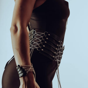Ceinture corset en cuir et chaînes inox, doublée de daim pour confort. Manchette en cuir italien avec chaîne en argent sterling. Ajustables, raffinées et sensuelles. Modèles sur commande.