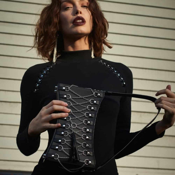Sac en cuir noir corseté par des chaînes en argent.