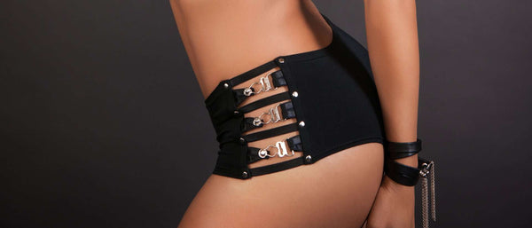 Femme portant un shorty noir avec des boucles métalliques vendu par Brigade Mondaine.