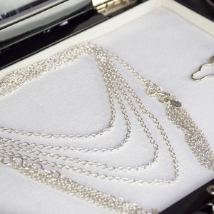 Collier Lalita en argent massif, chaîne enroulée quatre fois autour du cou avec pampilles suspendues de chaque côté. Une pièce élégante et fluide, apportant un effet raffiné et moderne à toute tenue.