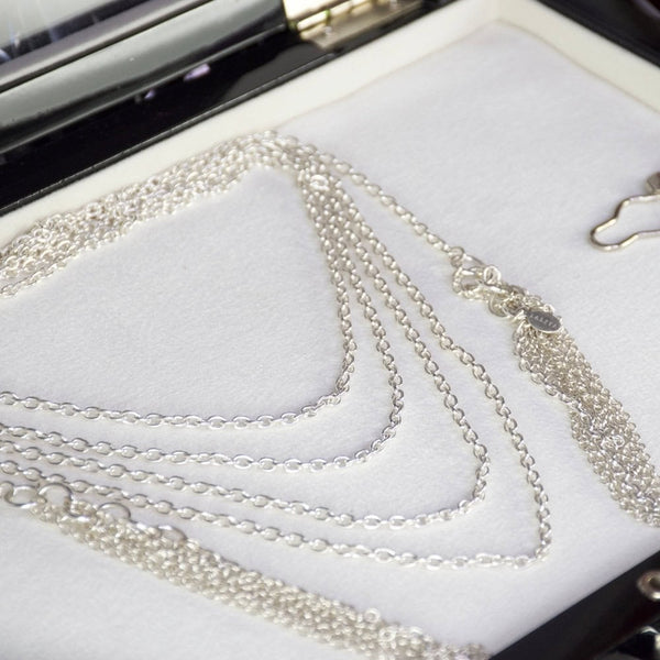 Collier Lalita en argent massif, chaîne enroulée quatre fois autour du cou avec pampilles suspendues de chaque côté. Une pièce élégante et fluide, apportant un effet raffiné et moderne à toute tenue.