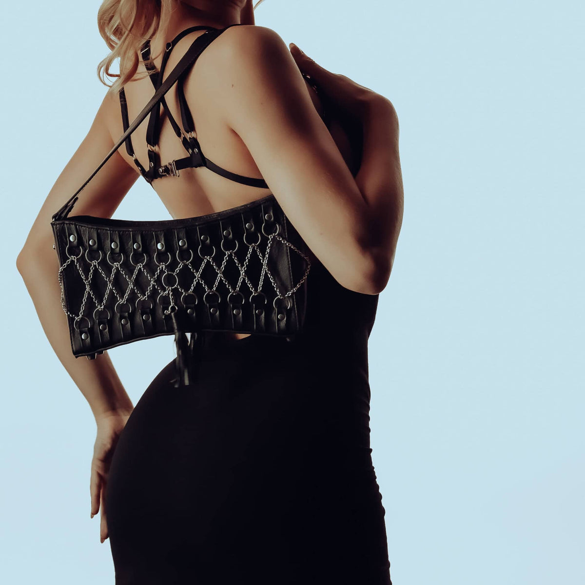 Robe convertible en bambou avec soutien-gorge harnais amovible, associée à un sac à main en cuir corseté avec détails en argent sterling et intérieur en daim violet. Audace, élégance et modularité.
