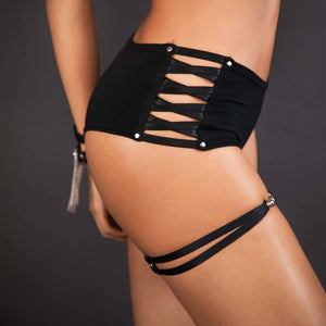 Lingerie féminine : une femme porte un shorty noir ajouré avec lanières croisées et attaches métalliques, alliant confort et élégance sexy.