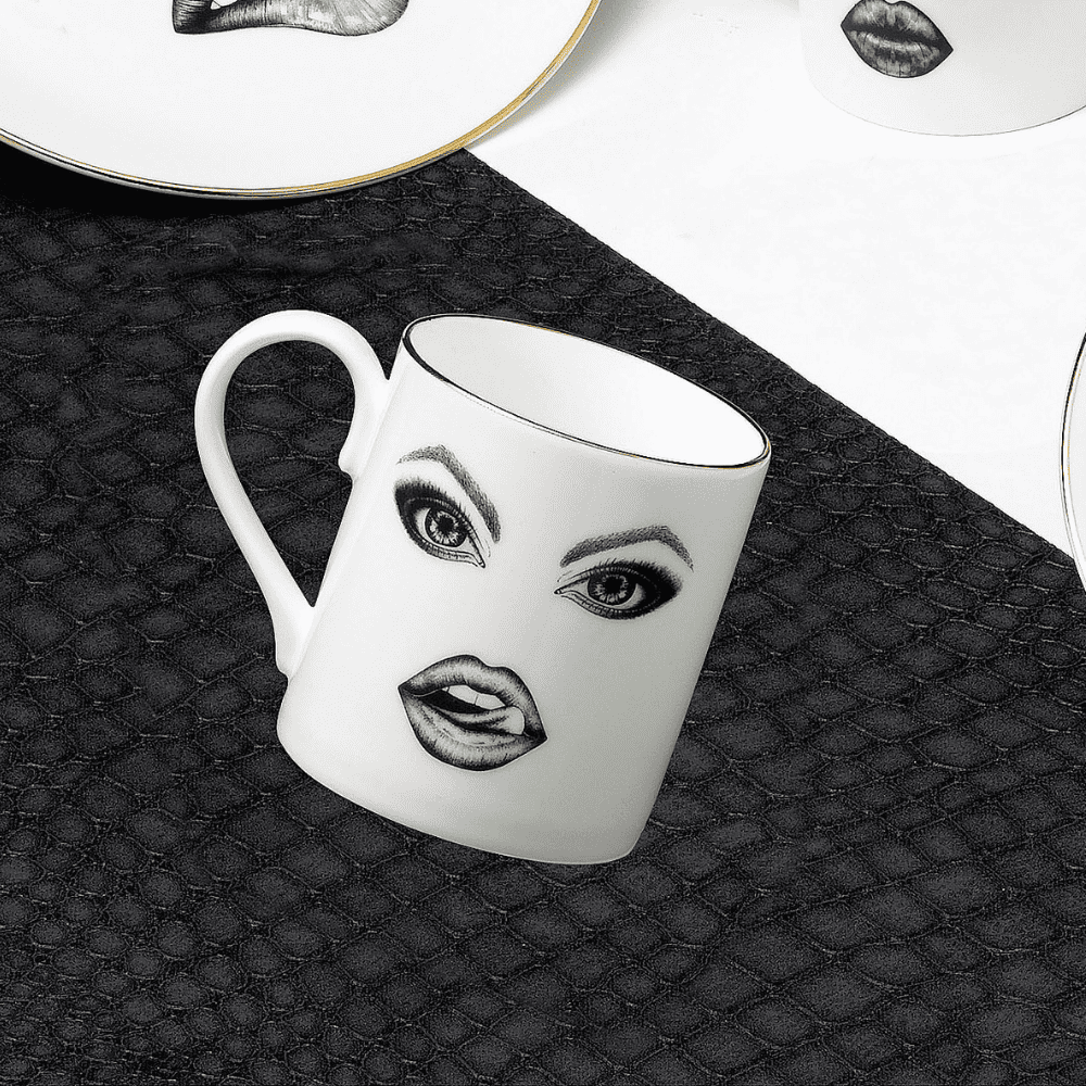 Une tasse en porcelaine blanche captivante, ornée d'un singe dessiné avec précision à la feutrine. Le singe taquine de manière espiègle, passant sa langue sur ses lèvres. L'illustration, réalisée avec finesse à l'aide d'un stylo à pointe fine, évoque le style Provocateur et puise son inspiration dans Ilona Staller.