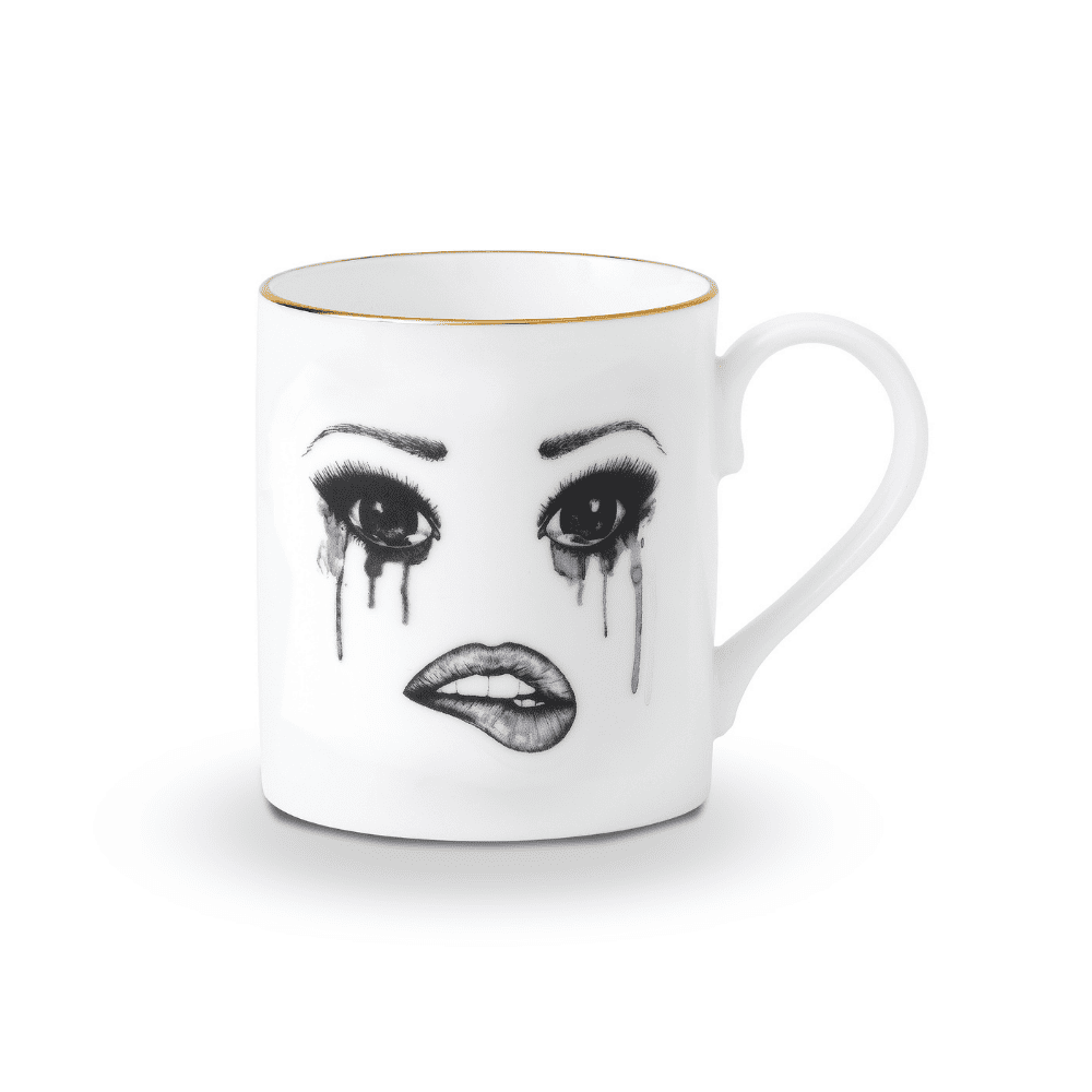 Une tasse en porcelaine chinoise blanche arbore un visage mélancolique, soigneusement tracé en feutrine. Ce visage exprime la tristesse avec des larmes coulant et un maquillage qui se fond, tandis que la lèvre inférieure est délicatement mordue, créant une composition émouvante et artistique.