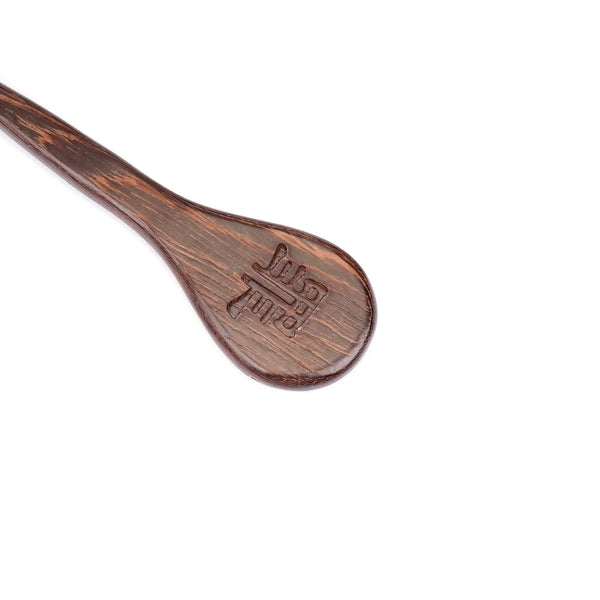 Paddle en bois wengé de la marque Liebe Seele, à la finition lisse avec dragonne de maintien, présenté sur fond clair dans l’univers Brigade Mondaine Paris.