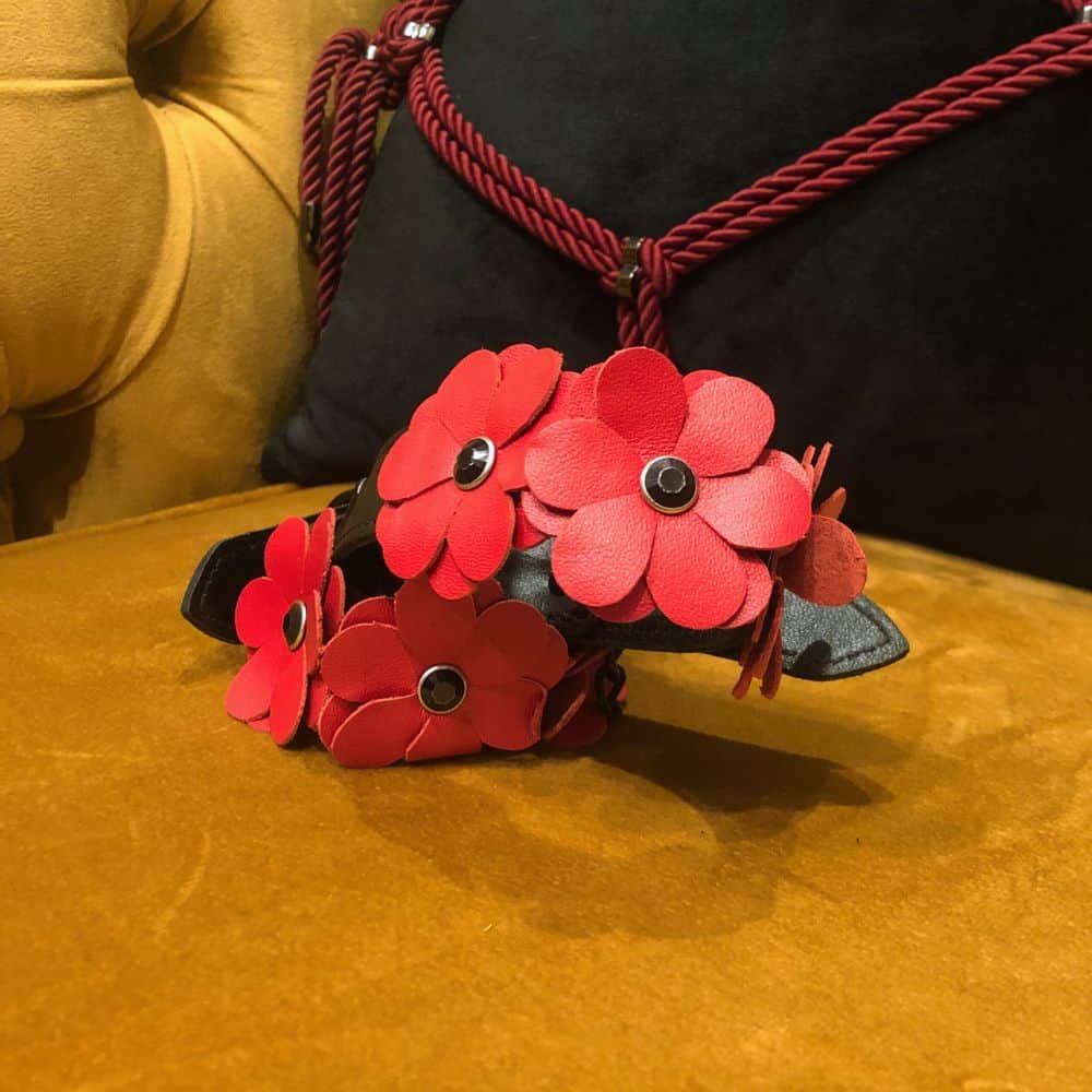 Image mettant en Scène les Packshot de Menottes en Cuir Noir avec Fleurs en Cuir Rouge et Chaine couleur Noir