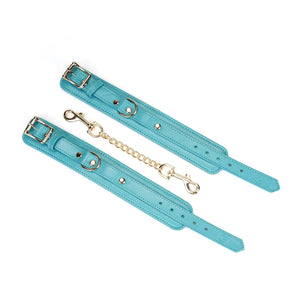 Menottes Agneau Bleu LIEBE SEELE en cuir bleu doublé agneau clair avec fermeture réglable, anneaux métalliques et chaîne dorée, photographiées sur fond blanc