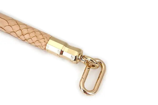 Barre d’écartement Snake BDSM LIEBE SEELE avec revêtement clair à motif reptile et mousquetons métalliques, accessoire haut de gamme proposé par Brigade Mondaine, sur fond blanc.