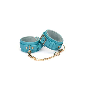 Menottes Agneau Bleu LIEBE SEELE en cuir bleu doublé agneau clair avec fermeture réglable, anneaux métalliques et chaîne dorée, photographiées sur fond blanc