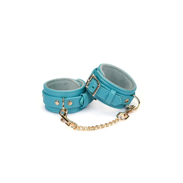 Menottes Agneau Bleu LIEBE SEELE en cuir bleu doublé agneau clair avec fermeture réglable, anneaux métalliques et chaîne dorée, photographiées sur fond blanc