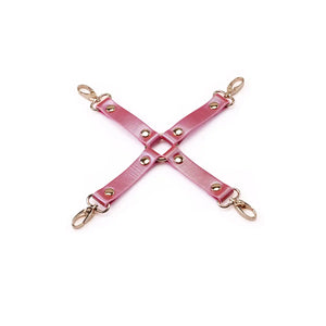 Hogtie Cuir Lustre Rosa LIEBE SEELE composé de sangles en cuir rose brillant avec rivets et mousquetons métalliques dorés, présenté à plat sur fond blanc