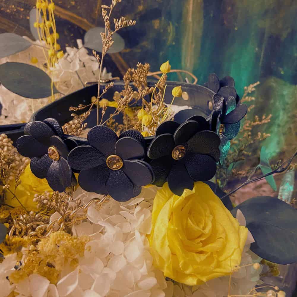 Collier en cuir au design fleur posé sur des fleurs.