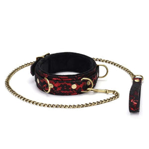Collier de bondage Victorian Garden en dentelle noire et cuir vegan rouge, avec détails dorés et laisse amovible. Élégant, confortable et ajustable, idéal pour des jeux BDSM raffinés.