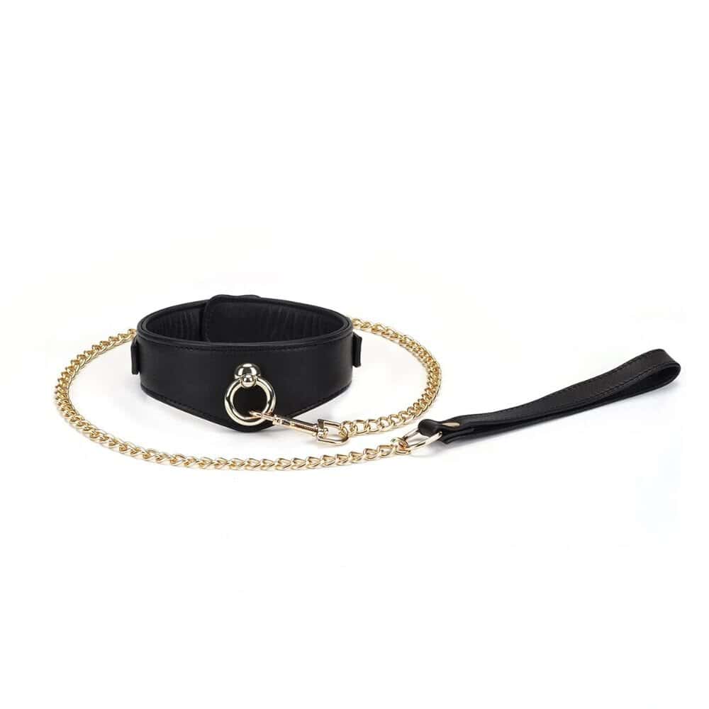Collier d’esclave Dark Secret en cuir noir avec laisse en chaîne dorée. Ajustable avec boucles métalliques et compatible avec divers accessoires BDSM. Conçu pour des jeux de domination sophistiqués.