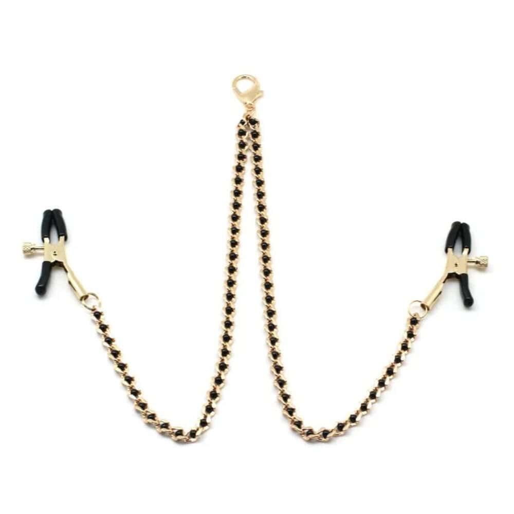 Chaîne avec pinces à tétons couleur or et perles noires, parfait pour le BDSM. Pinces réglables avec embouts en caoutchouc. Clip à dégagement rapide compatible avec différents colliers. Fabriqué en Chine.