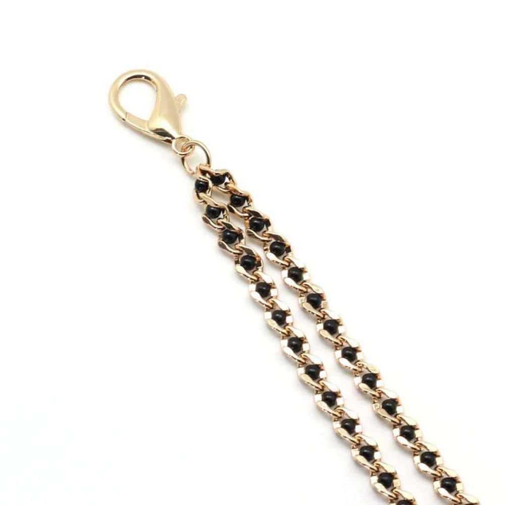 Chaîne avec pinces à tétons couleur or et perles noires, parfait pour le BDSM. Pinces réglables avec embouts en caoutchouc. Clip à dégagement rapide compatible avec différents colliers. Fabriqué en Chine.
