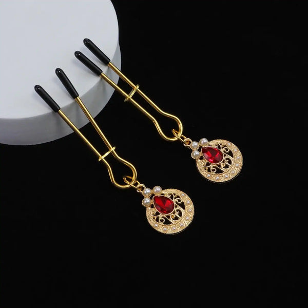 Pinces à tétons chaînes perles de la marque Liebe Seele, composées de pinces dorées reliées par une chaîne de perles blanches avec ornements sertis, présentées sur fond clair dans l’univers Brigade Mondaine Paris.