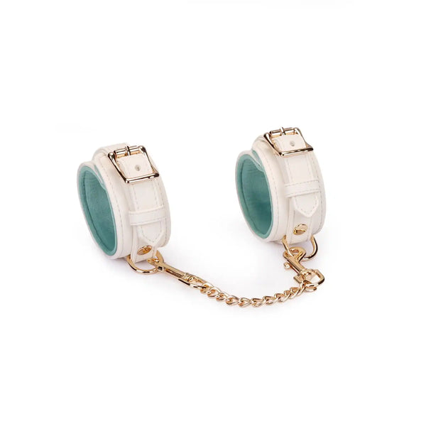 Menottes Boudoir Amor de la marque Liebe Seele, en cuir clair avec chaîne et mousquetons dorés, présentées à plat sur fond clair dans l’univers Brigade Mondaine Paris.