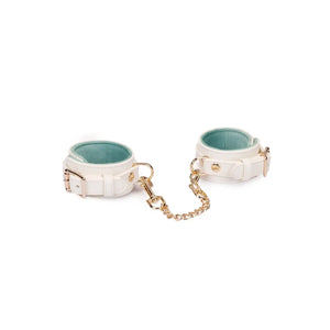 Menottes Boudoir Amor de la marque Liebe Seele, en cuir clair avec chaîne et mousquetons dorés, présentées à plat sur fond clair dans l’univers Brigade Mondaine Paris.