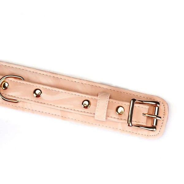Collier de bondage Pink Boudoir Amor en similicuir vegan rose et noir. Finitions dorées, trois anneaux en D pour fixation. Avec laisse en chaîne dorée, élégant et ajustable pour une domination raffinée.