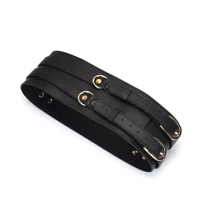 Ceinture de bondage en cuir noir de la collection Dark Secret. Fabriquée à la main avec des finitions dorées et deux anneaux en D pour fixation. Accessoire de domination luxueux et raffiné.