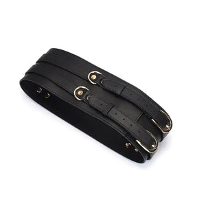 Ceinture de bondage en cuir noir de la collection Dark Secret. Fabriquée à la main avec des finitions dorées et deux anneaux en D pour fixation. Accessoire de domination luxueux et raffiné.