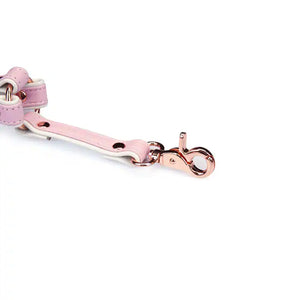 Hogtie en cuir rose et blanc de la collection Fairy, en cuir d'agneau avec clips métalliques or rose. Accessoire BDSM pour immobiliser totalement, alliant douceur et soumission dans un design pastel élégant.