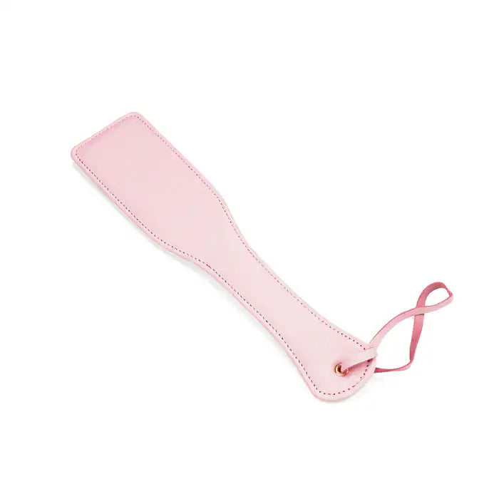 Paddle en cuir rose de la collection Fairy, confectionné en cuir d'agneau blanc et rose avec accents or rose. Un accessoire BDSM raffiné pour des jeux de fessée contrôlés et élégants.