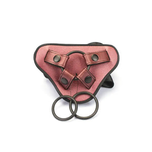 Harnais Strap-On Pink LIEBE SEELE avec base structurée rose, sangles noires réglables et anneaux métalliques, présenté à plat sur fond blanc, vue produit détaillée