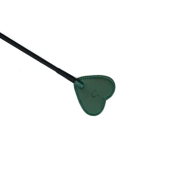 La cravache en cuir à embout cœur de la collection Mossy Chic allie cuir vert profond et finition métallique dorée. Son embout en forme de cœur imprime des traces délicates mais marquantes, tandis que le manche en cuir tressé assure une prise parfaite. La dragonne en cuir permet un contrôle optimal, créant un équilibre parfait entre élégance et discipline. À combiner avec d'autres accessoires de la collection pour des jeux BDSM raffinés.