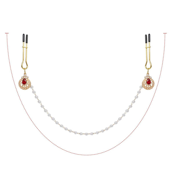 Pinces à tétons chaînes perles de la marque Liebe Seele, composées de pinces dorées reliées par une chaîne de perles blanches avec ornements sertis, présentées sur fond clair dans l’univers Brigade Mondaine Paris.