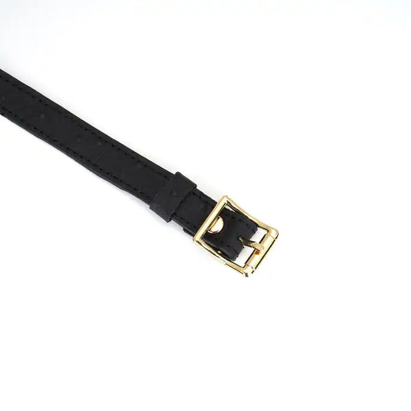 Choker en cuir noir embossé avec lettres argentées SLUT et finitions dorées. Accessoire ajustable, souple et confortable, parfait pour jeux BDSM et tenues fétichistes.