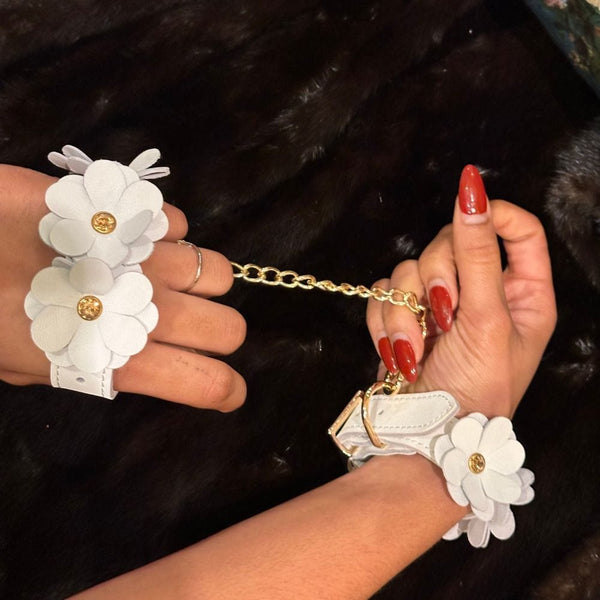 Image des Menottes en Cuir Blanc avec Fleurs en Cuir Blanc et Chaine Dorée avec Fond Fourrure Noir