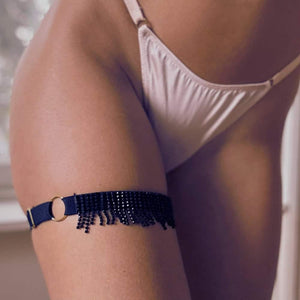 Femme de 3/4 portant une Jarretière élastique Noire avec Franges de Strass Noirs