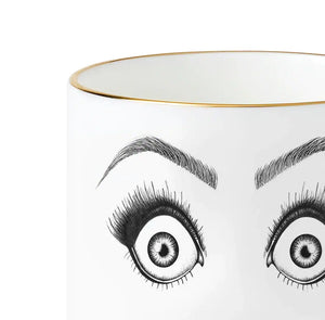 Détail d’une tasse en porcelaine chinoise blanche présente un dessin en feutrine noire illustrant un visage surpris avec des yeux très choqués et une bouche ouverte, le tout rehaussé de détails dorés.