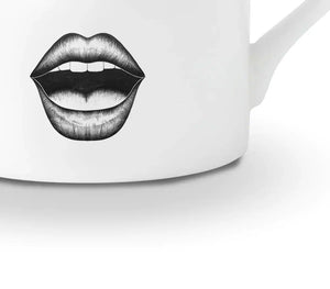 Détail d’une tasse en porcelaine chinoise blanche présente un dessin en feutrine noire illustrant un visage surpris avec des yeux très choqués et une bouche ouverte, le tout rehaussé de détails dorés.