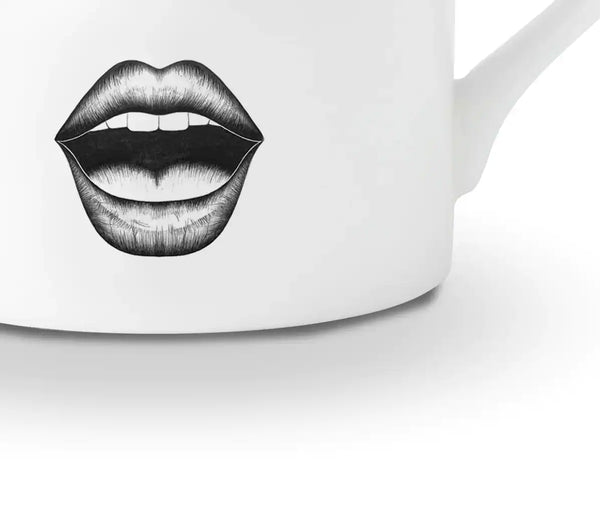 Détail d’une tasse en porcelaine chinoise blanche présente un dessin en feutrine noire illustrant un visage surpris avec des yeux très choqués et une bouche ouverte, le tout rehaussé de détails dorés.