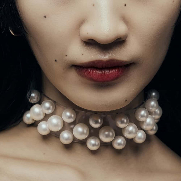 Modèle portant le Boudoir Choker Perlensau avec perles blanches montées sur base transparente, proposé par Brigade Mondaine Paris.