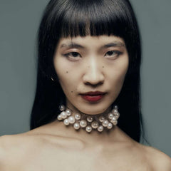 Modèle portant le Boudoir Choker Perlensau avec perles blanches montées sur base transparente, proposé par Brigade Mondaine Paris.