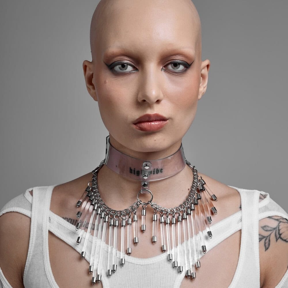 Modèle portant le Cosmic Choker Perlensau en matière transparente avec chaînes métalliques et pampilles suspendues, proposé par Brigade Mondaine Paris.