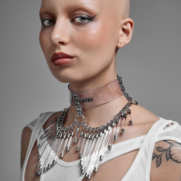 Modèle portant le Cosmic Choker Perlensau en matière transparente avec chaînes métalliques et pampilles suspendues, proposé par Brigade Mondaine Paris.